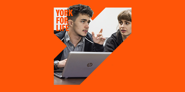 two students working on a laptop as part of a York for Life branded image